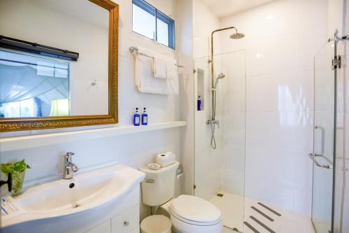 a bathroom with a toilet and a sink and a shower at Villa Amphawa in Amphawa