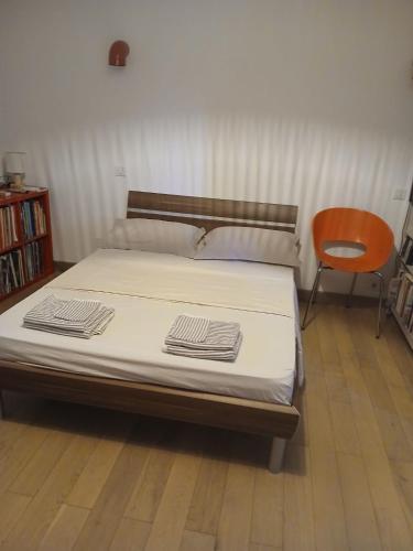 - un lit dans une pièce avec une chaise dans l'établissement Chambre chez l'habitant avec piscine et cuisine d'été, à Saint-Martin-de-la-Brasque