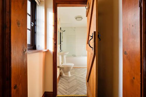 a bathroom with a toilet and a bath tub at Finest Retreats - Walton Maisonette in Onibury