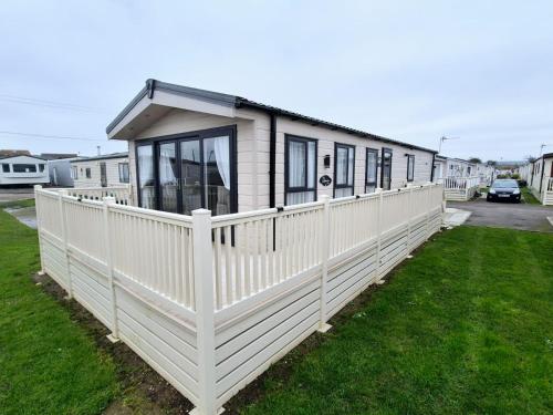 a row of mobile homes with a white fence at Whitstable Delta Superior in Seasalter