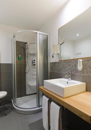 a bathroom with a sink and a shower at Cevedale Living Romance Hotel in Cogolo
