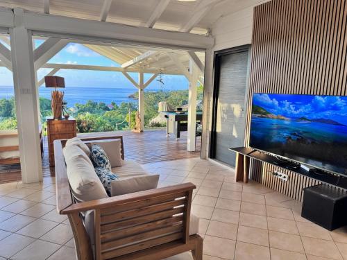 デエエにあるVilla Franco - Plage de Leroux à 600m - Vue mer exceptionnelleのソファと大型テレビのあるリビングルーム