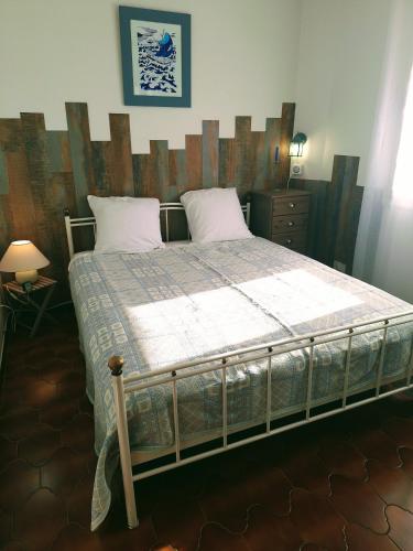 une chambre avec un grand lit avec une tête de lit en bois dans l'établissement T2 belle terrasse avec vue sur mer, à Port-Vendres