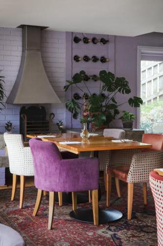 a dining room with a wooden table and purple chairs at The Beeley Inn - Chatsworth in Beeley