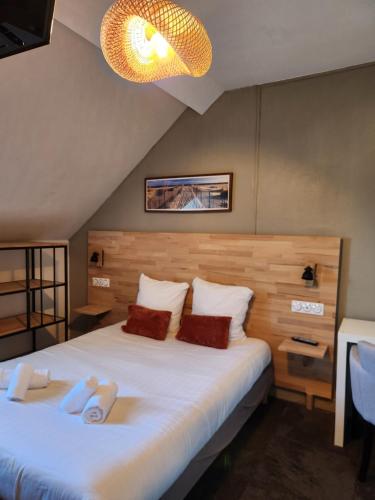 a bedroom with a large bed with two slippers on it at Le petit Montmartre in Dinard