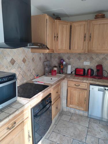 une cuisine avec des armoires en bois, un évier et une cuisinière dans l'établissement aucun, à Saint-Rémy-de-Provence