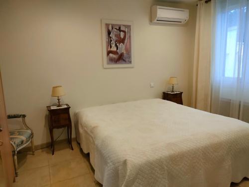 une chambre avec un lit blanc et une fenêtre dans l'établissement aucun, à Saint-Rémy-de-Provence