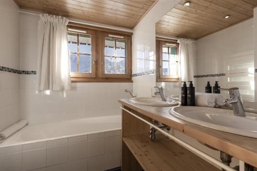 La salle de bains est pourvue d'une baignoire, de deux lavabos et d'une baignoire tubermottermott. dans l'établissement Chalet Marie Paradis vue Mont Blanc, à Saint-Gervais-les-Bains