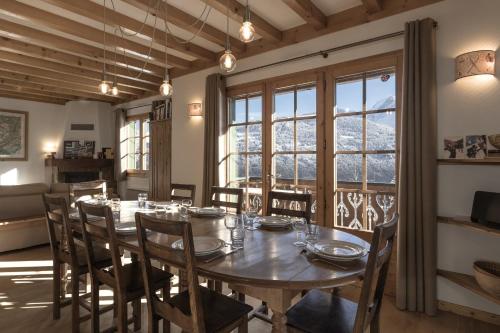 une salle à manger avec une table et des chaises et une fenêtre dans l'établissement Chalet Marie Paradis vue Mont Blanc, à Saint-Gervais-les-Bains