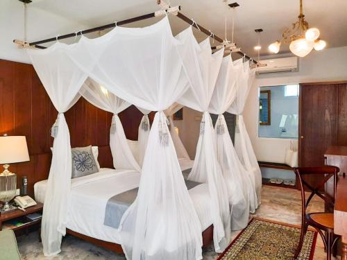 a bedroom with a bed with white mosquito nets at Villa Amphawa in Amphawa