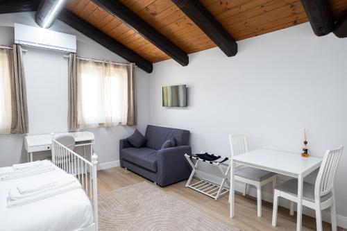 a room with a bed and a table and a couch at Dimora Santa Rosalia in Alba