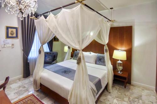 a bedroom with a bed with a canopy at Villa Amphawa in Amphawa