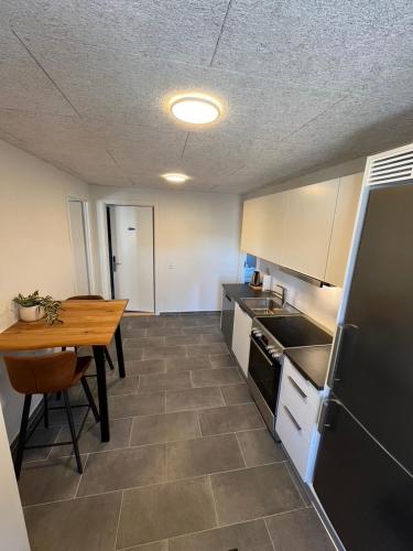 a kitchen with a table and a table and a refrigerator at Go-Sleep Bredehus in Bredsten