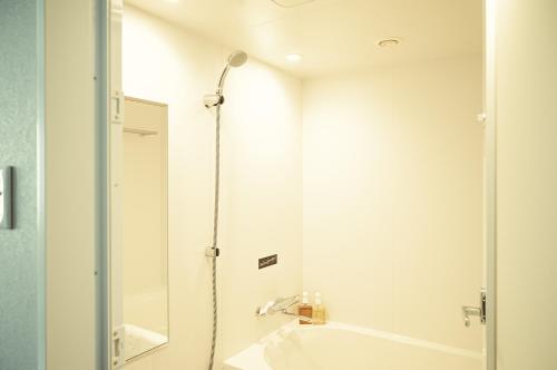 a bathroom with a shower and a sink at Hotel It Osaka Shinmachi in Osaka