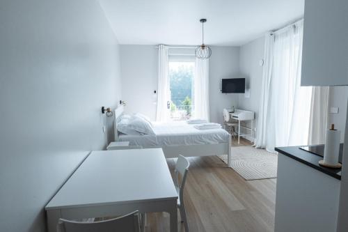 a white room with a bed and a desk at Dimora Santa Rosalia in Alba