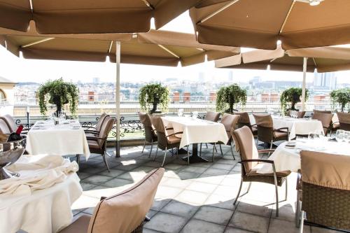 a patio area with tables, chairs and umbrellas at Le Palais Art Hotel Prague in Prague