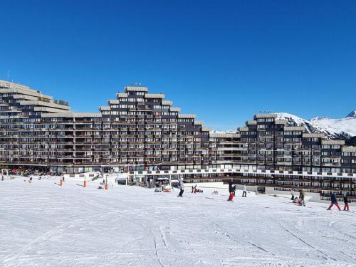 un groupe de bâtiments sur une plage dans la neige dans l'établissement Studio fonctionnel aux pieds des pistes, 4 pers, casier à skis - FR-1-181-2592, à Aime La Plagne
