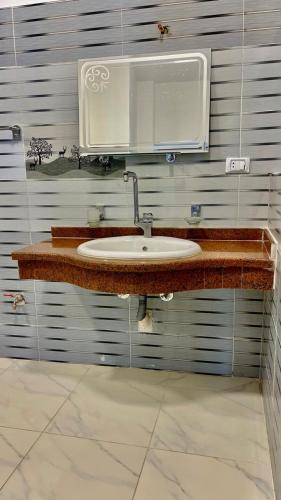 un baño con lavabo y espejo en Alhadi Guest house, en Luxor