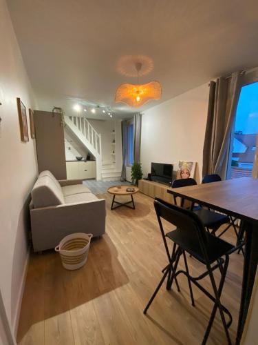 un salon avec un canapé et une table dans l'établissement Duplex, à Cormeilles-en-Parisis