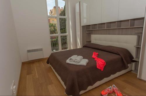 - une chambre avec un lit et une paire de chaussons dans l'établissement Superb 50m2 condominium apartment with swimming pool, à Menton