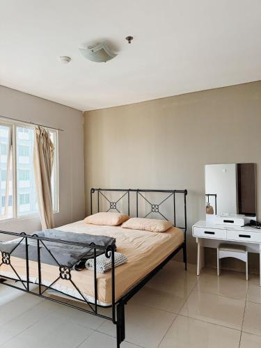 a bedroom with a black bed and a desk at Premium Getaway in City Central in Jakarta