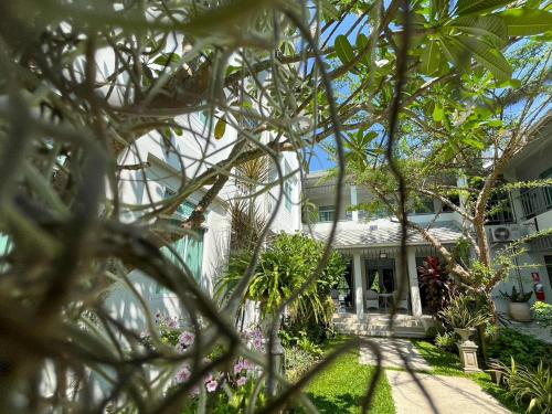 a house seen through the leaves of trees at Villa Amphawa in Amphawa