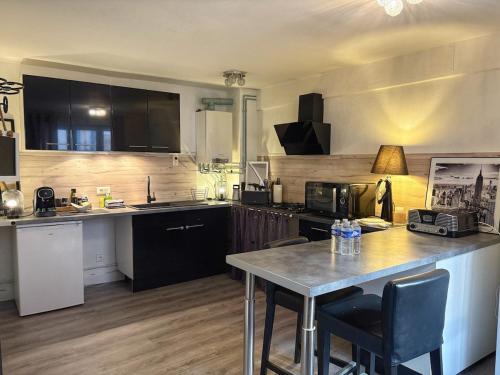 une cuisine avec un comptoir et une table avec des chaises dans l'établissement Maison Beauté, à Tournus