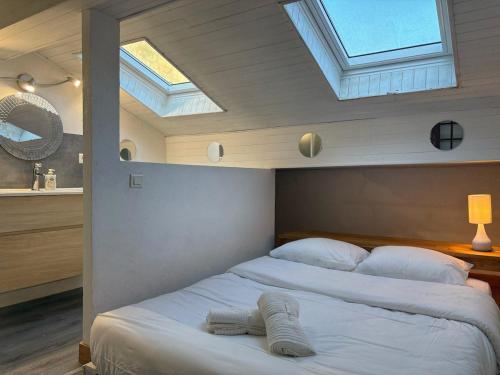a bedroom with two beds in a room with skylights at Maison Beauté in Tournus