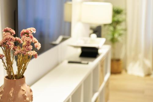 a vase with flowers on a counter in a room at NEU - Stilvolle & zentrale Ferienwohnung mit Komfort in Wittlich - Zentrum - 4 Personen - 2 Schlafzimmer - Netflix - Waschmaschine in Wittlich