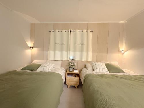 two beds sitting next to each other in a bedroom at Doors Seongsu in Seoul