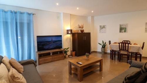 a living room with a couch and a tv and a table at Apartamento a 50 metros do Santuário de Fátima in Fátima