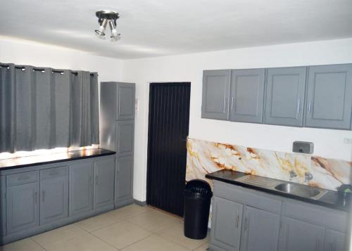 a kitchen with gray cabinets and a sink at Linden Guest House in Johannesburg