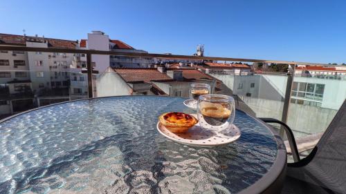 a table with two glasses and a plate of food on it at Apartamento a 50 metros do Santuário de Fátima in Fátima