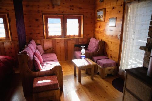 a room with two couches and a table in a cabin at Chalet "Chez le petit Jean" in Evolène