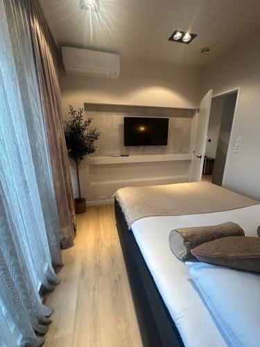 a bedroom with two beds and a flat screen tv at Palace Hotel Zandvoort in Zandvoort