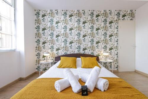 une chambre avec un lit avec des serviettes dessus dans l'établissement Le havre de paix Tolosan, à Toulouse