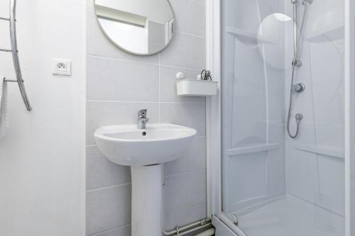 une salle de bain blanche avec un lavabo et une douche dans l'établissement Le havre de paix Tolosan, à Toulouse
