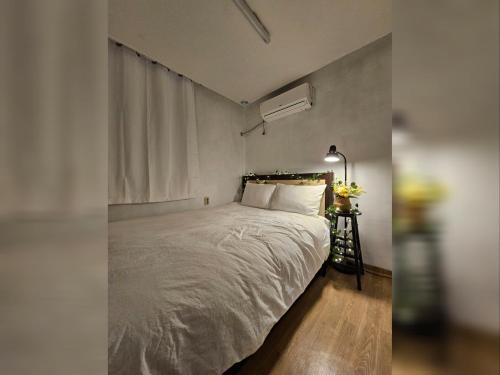 a bedroom with a white bed with a window at lunastay in Cheongju
