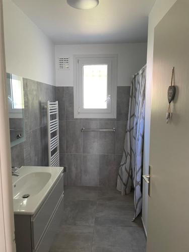 une salle de bain avec un lavabo et des toilettes et une fenêtre dans l'établissement Maison bord de mer, à Saint-Pierre-dʼOléron