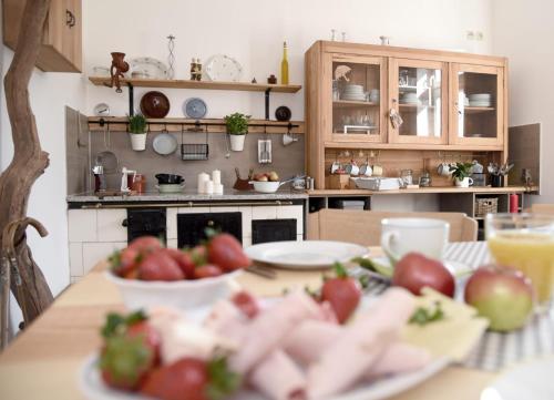 a kitchen with a table with plates of fruit on it at Gästehaus Wagner in Chemnitz
