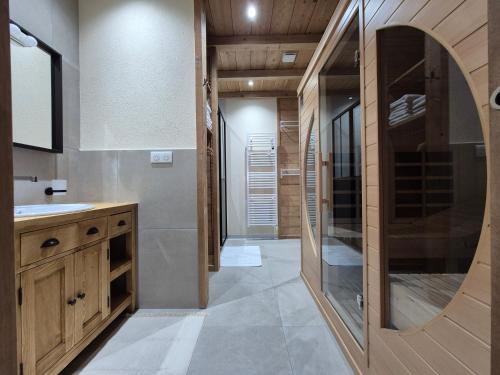 une salle de bain avec un lavabo et un miroir dans l'établissement DEL VINO bar à vin & guitares Appartement Sauna Terrasse Garage, à Orchamps-Vennes