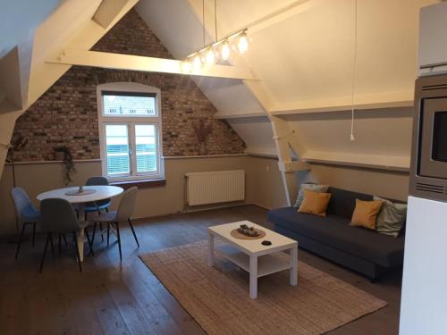a living room with a couch and a table at attic apartment in the center in Gouda