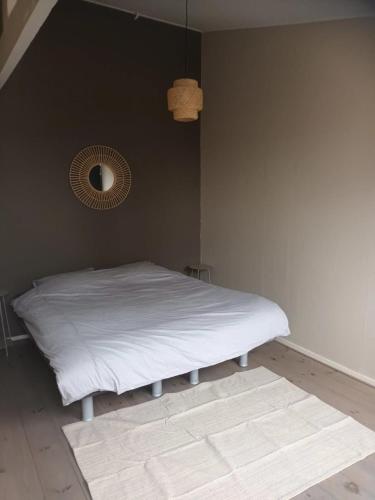 a bedroom with a white bed and a mirror at attic apartment in the center in Gouda