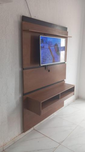 a entertainment center with a tv on a wall at Casa de praia em Japaratinga.(Pé na areia!) in Japaratinga