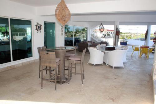a dining room with white chairs and a table at Vista Marina Residence in Boca Chica