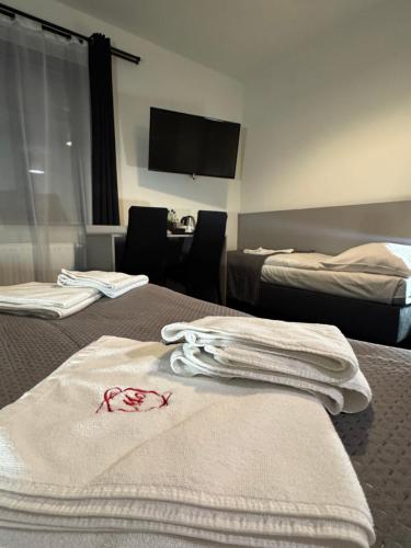 a hotel room with two beds with towels on the bed at Medical Wellness & SPA Werona in Duszniki Zdrój