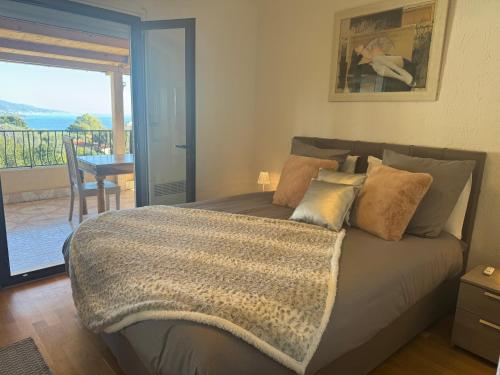 - une chambre avec un lit et un balcon dans l'établissement Appartement villa toit terrasse, à Menton