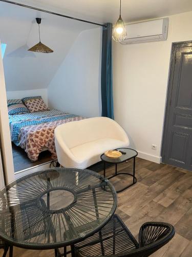 un salon avec un lit et une table en verre dans l'établissement Studio centre ville Rodez, à Rodez