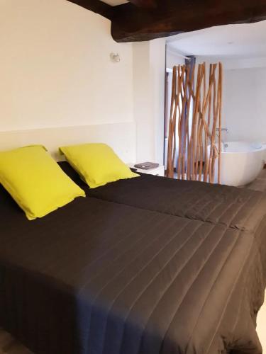 - un lit avec 2 oreillers jaunes au-dessus dans l'établissement Appartement charmant à Sare avec vue sur la montagne, à Sare