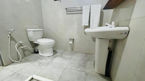a bathroom with a toilet and a sink at Jungle Edge Home Sigiriya in Sigiriya